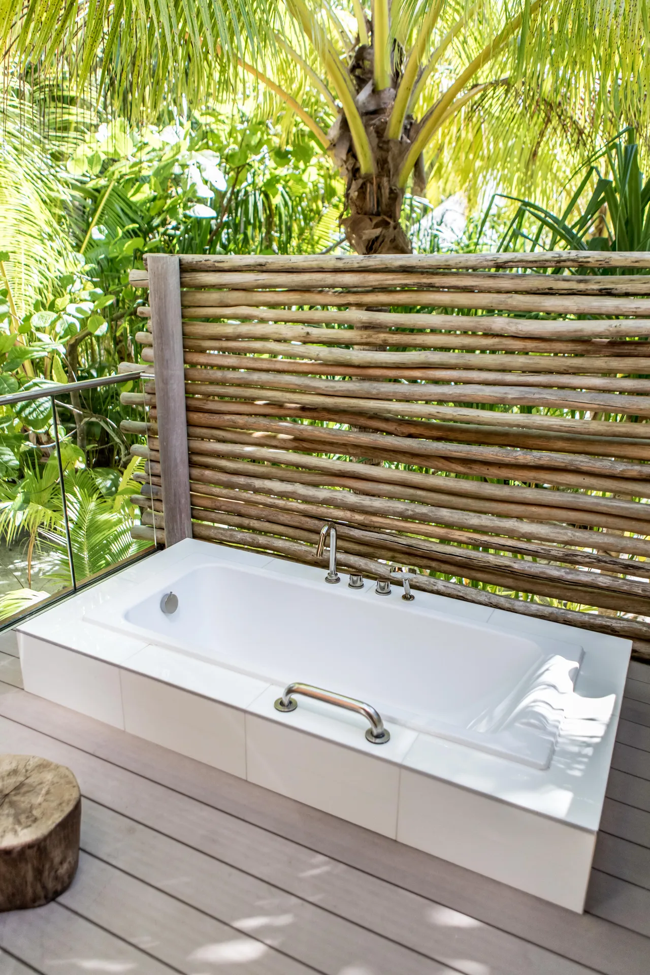 Outdoor bathtub surrounded by plants